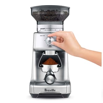 User selecting grind size using the setting wheel.