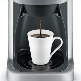 Coffee brewing directly into a travel mug.