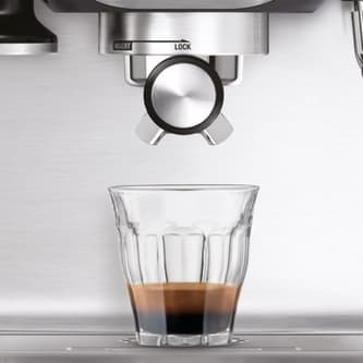 A glass off coffee sitting under the coffee spouts of the Dup-Temp Pro.