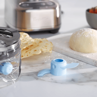 Close up of the dough blade next to a ball of dough