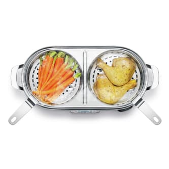 Carrots being cooked in one compartment and two chicken legs being cooked in the other.