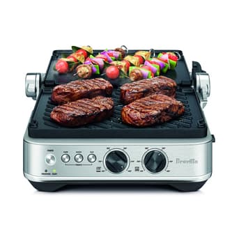 Steaks and skewers being grilled.