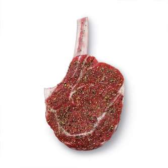 A beef cutlet with sprinkled seasoning.