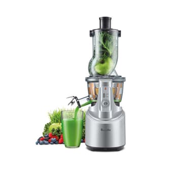 Fresh fruit and vegetables going through chute, making green juice.