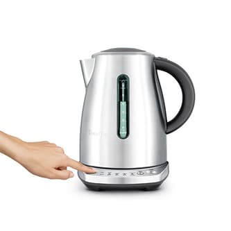 Side view of kettle with hand selecting button to keep kettle warm.