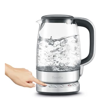 Side view of the kettle with hand selecting temperature setting.