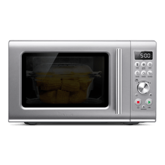 Front view of the microwave with door closed cooking sweetcorn.