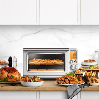The Smart Oven Air Fryer XL with hot chips, a roast chicken and completed meals