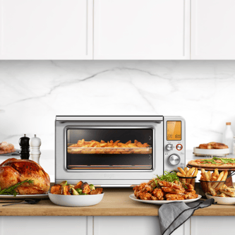 The Smart Oven Air Fryer XL with hot chips, a roast chicken and completed meals