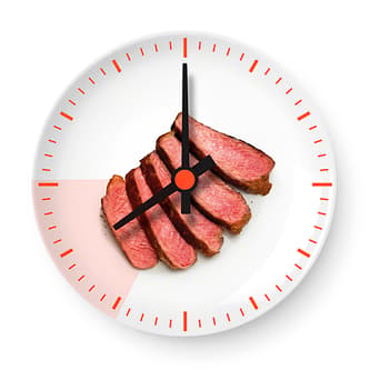 Red meat on white plate that resembles a clock