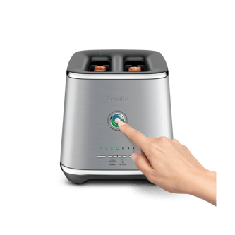 A hand reached out to press a button of the Eye Q™ Auto 2 Slice