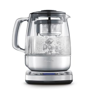 Side view of kettle with infuser boiling water.