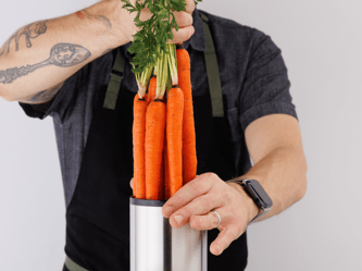 Carrots being tossed into the chute ahead of juicing