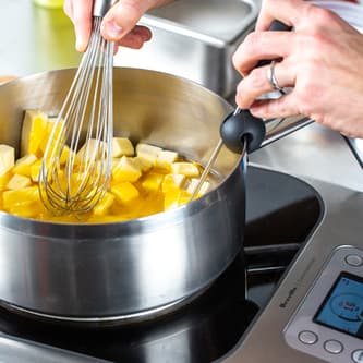 The probe measures the temperature of butter melting in a pot on top of the precision cooker.