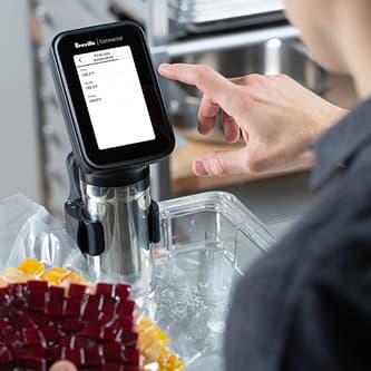 A person touches the screen of the HydroPro™ which is immersed in a container of water.