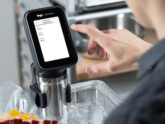 A person touches the screen of the HydroPro™ which is immersed in a container of water.