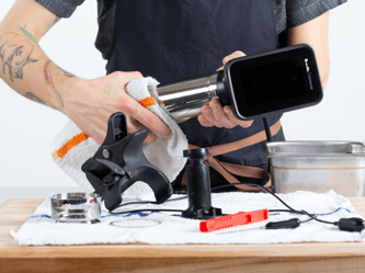 A person cleans the cylindrical component of the HydroPro™ with a cloth.