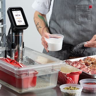 The HydroPro™ is immersed in a body of water while the chef seasons the meat.