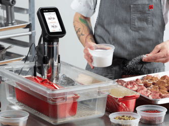 The HydroPro™ is immersed in a body of water while the chef seasons the meat.