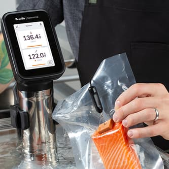 A digital needle probe that is connected to the main device is measuring the core temperature of a piece of salmon.