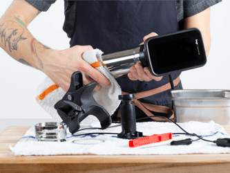 A person cleans the cylindrical component of the HydroPro™ Plus with a cloth.
