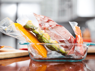 Vacuum sealed meats and vegetables in a glass container.