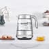 The smart crystal luxe kettle next to a plate of biscuits and cup of tea