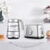 The smart crystal luxe kettle and toaster next to a cup of tea and bread