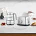 The smart crystal luxe kettle and toaster next to a cup of tea and biscuits