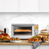 The Smart Oven Air Fryer XL with hot chips, a roast chicken and completed meals